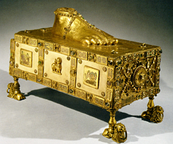Ornate gold reliquary with a gold foot on the top