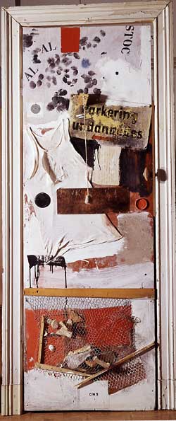 Collage, including a white undershirt and chicken wire, on a painted door with doorframe