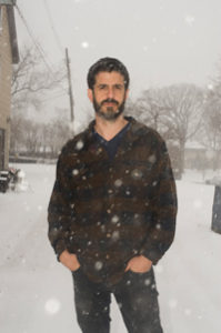 A man in a plaid shirt standing in the snow