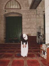 woman hunched over in front of stone wall