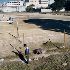 Barrada, boy crawling under fence of soccer field