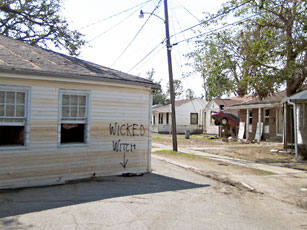 photo of dilapidated house with spraypainted with  "wicked witch" 