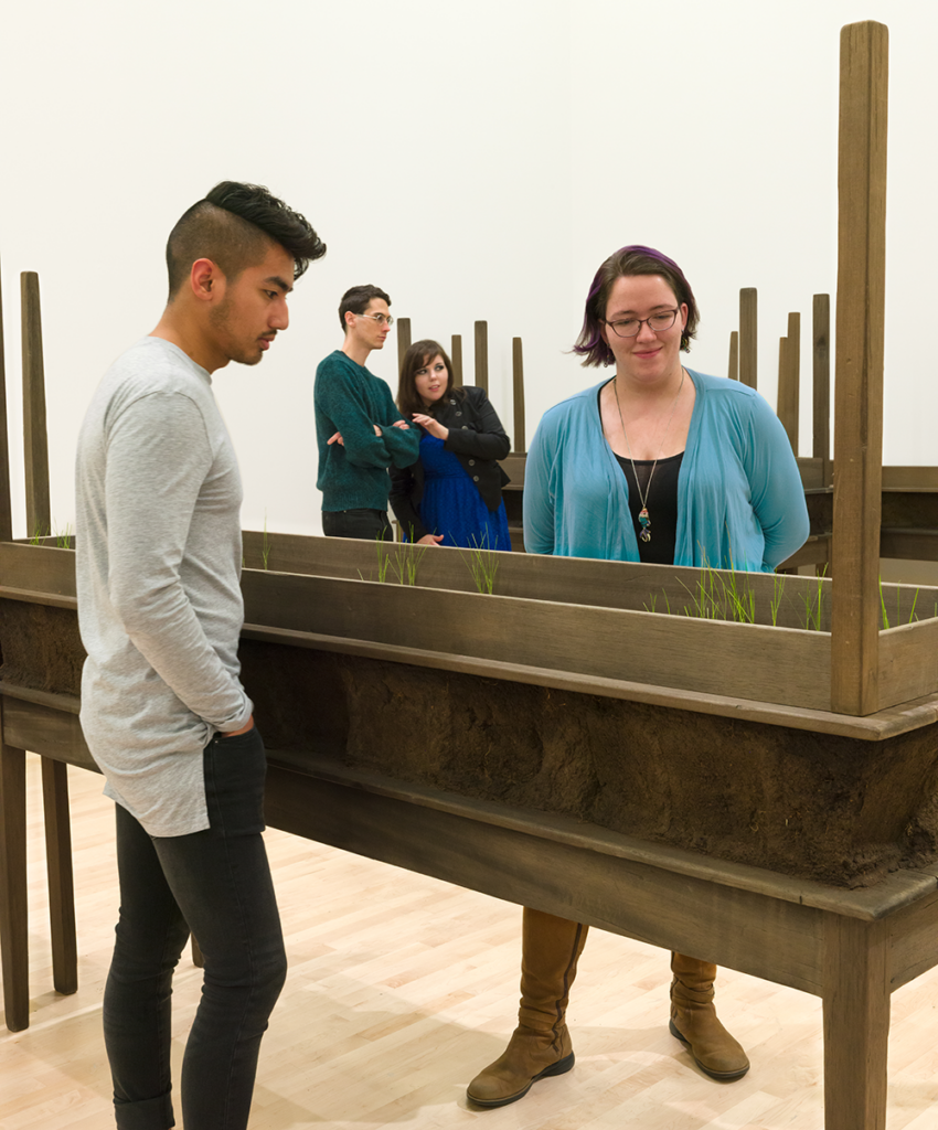 Four visitors look at Doris Salcedo's Plegaria Muda