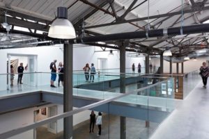A group of people gather in an airy architectural setting