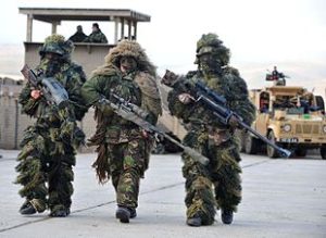 Soldiers wearhing ghillie suits hold guns