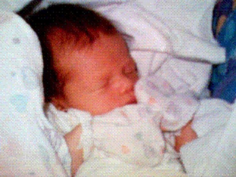 photograph of a baby in heart print clothing and blanket