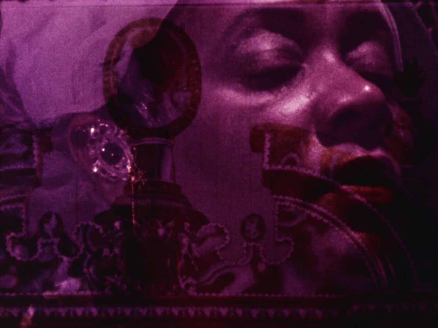 Artistic film still depicting a woman's face overlayed with the sillouettes of decorative antiques.