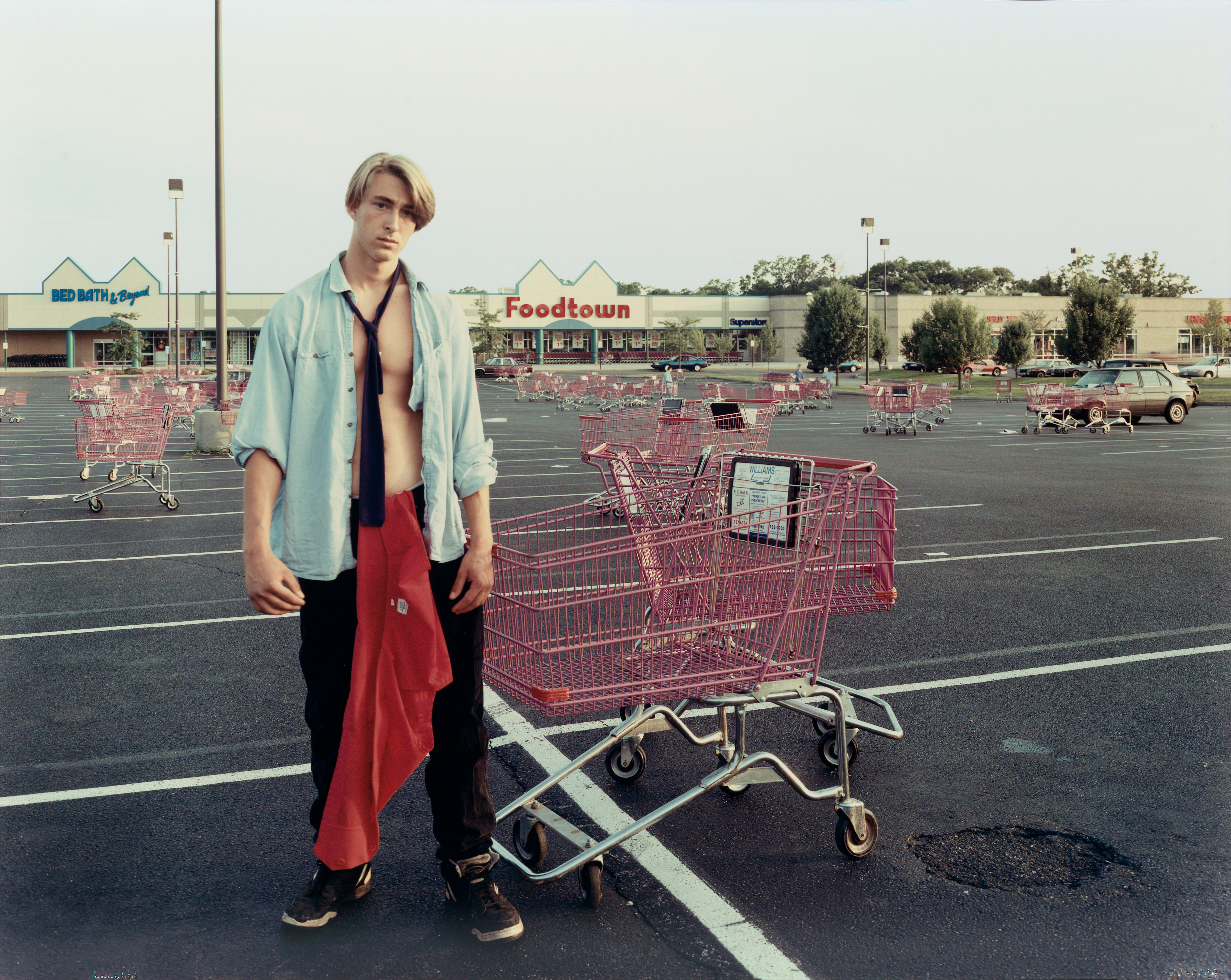 Joel Sternfeld, A Young Man Gathering Shopping Carts